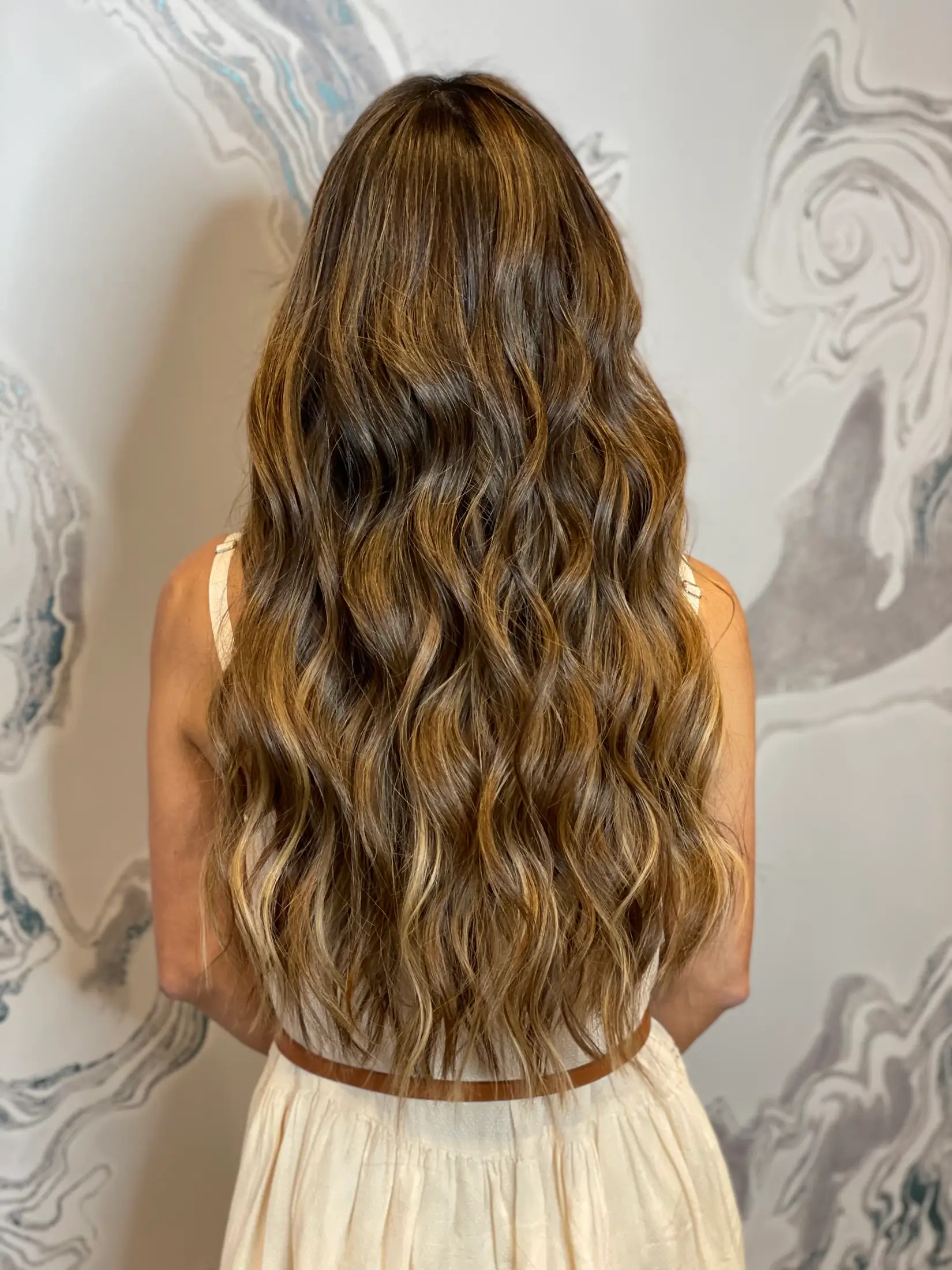 Full-length caramel hair extensions photographed from behind