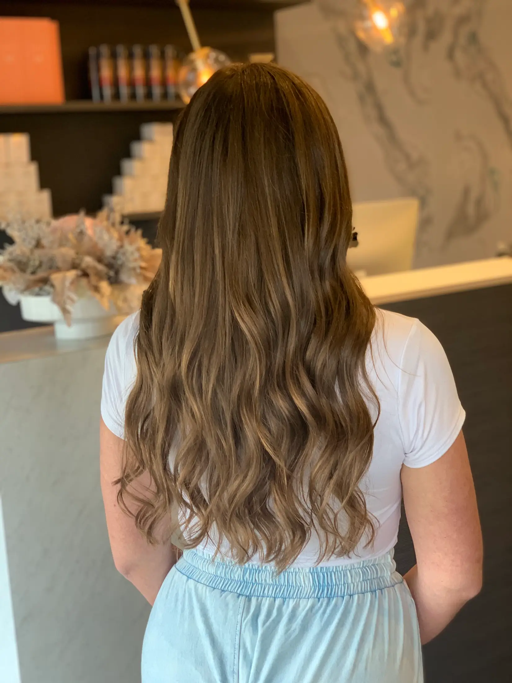 Hair extensions worn long and natural, photographed from behind